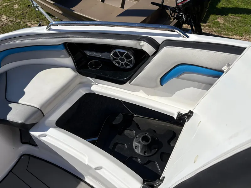 Slide: The Image of 2019 Yamaha Boats 242X E-Series interior with white and blue seating and speaker system. - 22