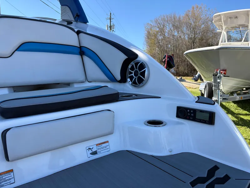 Slide: The Image of 2019 Yamaha Boats 242X E-Series interior with speaker and seating, outdoors on a sunny day. - 3