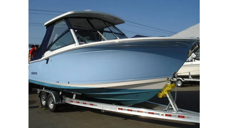 Slide: The Image of 2022 Blackfin 272 DC boat on trailer, light blue hull, dual console design. - 0