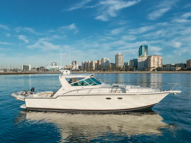 Slide: The Image of 1996 Tiara Yachts 4300 cruising on calm water with city skyline backdrop. - 0