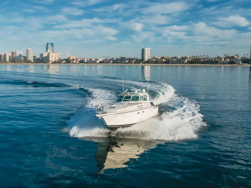 Slide: The Image of 1996 Tiara Yachts 4300 cruising on calm waters near a city skyline. - 1