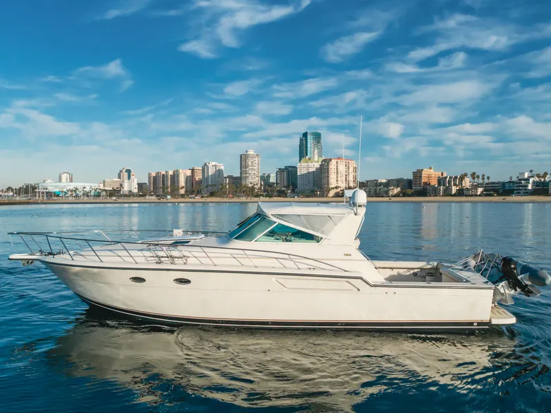 Slide: The Image of 1996 Tiara Yachts 4300 cruising on calm waters with city skyline backdrop. - 10