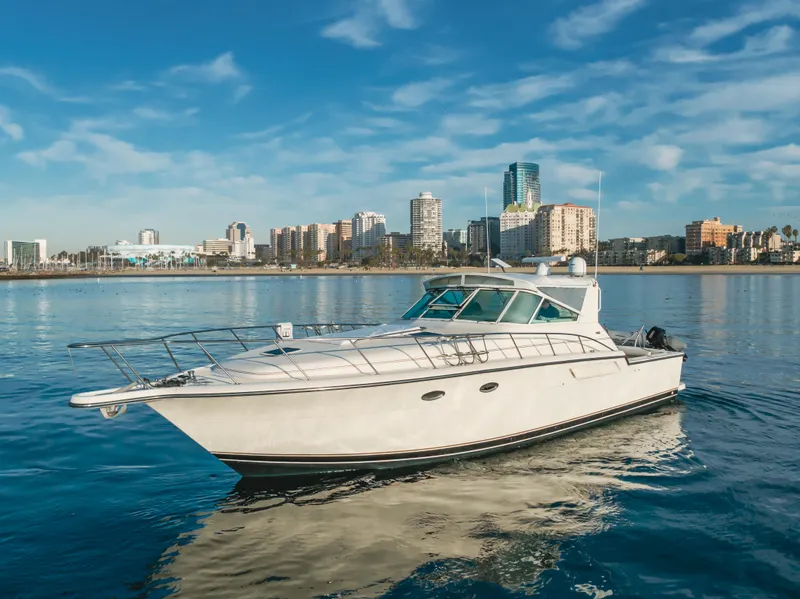 Slide: The Image of 1996 Tiara Yachts 4300 cruising on calm waters with city skyline backdrop. - 11