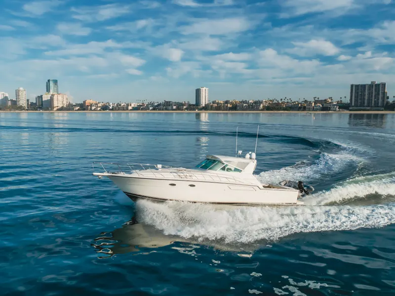 Slide: The Image of 1996 Tiara Yachts 4300 cruising on calm waters near a city skyline. - 14