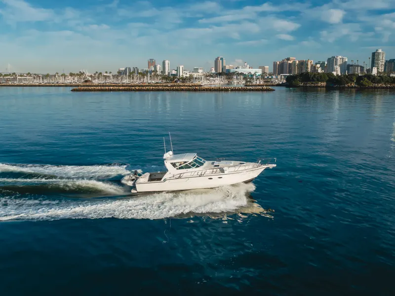 Slide: The Image of 1996 Tiara Yachts 4300 cruising on calm waters with city skyline in background. - 19