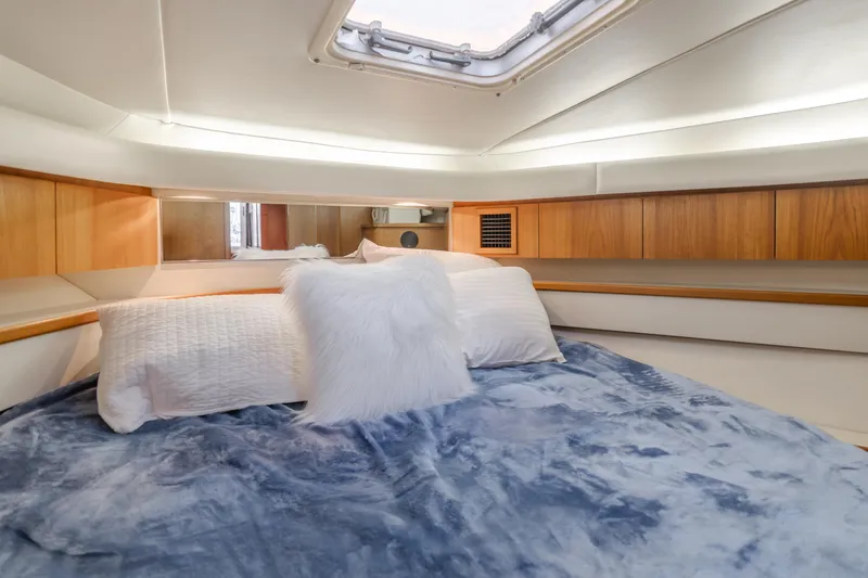 Slide: The Image of Luxurious cabin interior of a 1996 Tiara Yachts 4300, featuring cozy bedding and wood accents. - 21