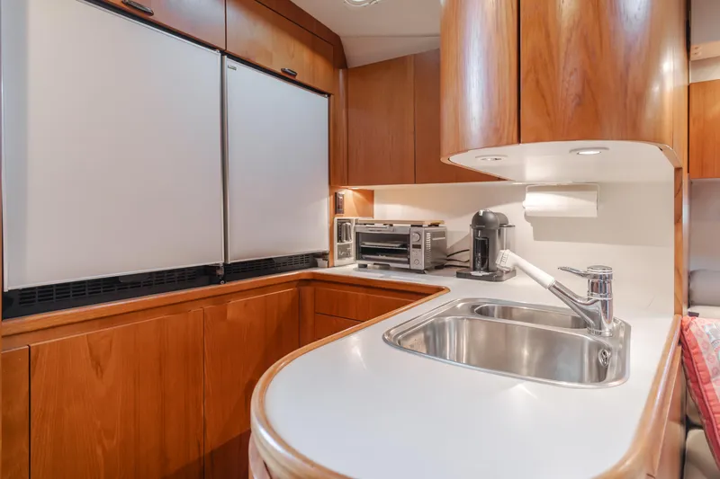 Slide: The Image of 1996 Tiara Yachts 4300 kitchen with wood cabinets, sink, and appliances. - 27