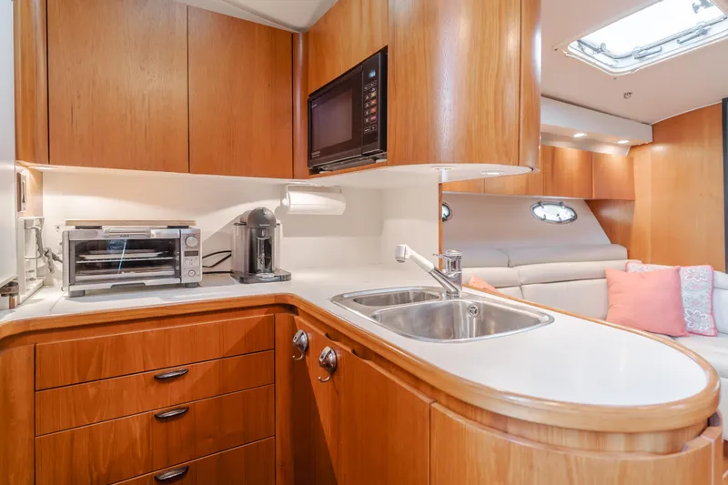 Slide: The Image of Luxurious 1996 Tiara Yachts 4300 interior kitchen with wood cabinetry and modern appliances. - 28