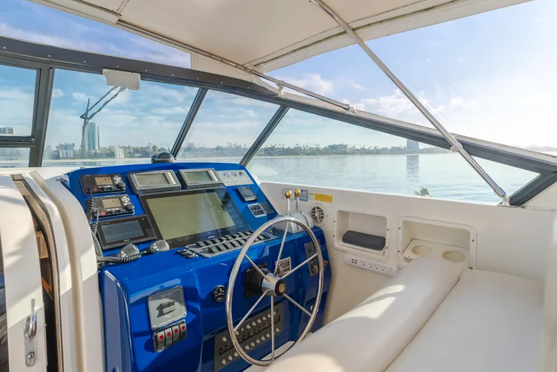 Slide: The Image of Helm of 1996 Tiara Yachts 4300 with blue dashboard and scenic water view. - 3