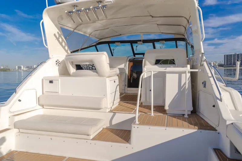 Slide: The Image of 1996 Tiara Yachts 4300 boat interior with seating and helm, under clear blue sky. - 35