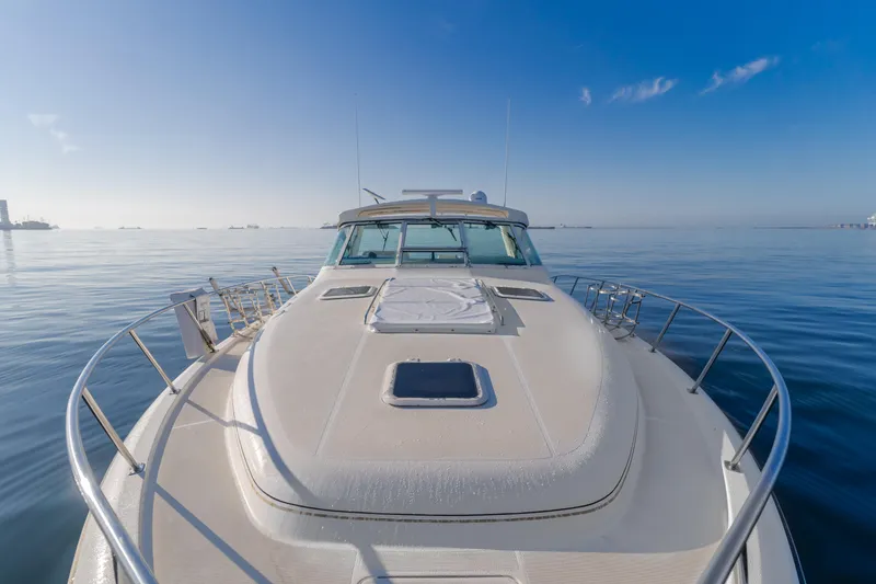 Slide: The Image of 1996 Tiara Yachts 4300 on calm water under clear blue sky. - 43