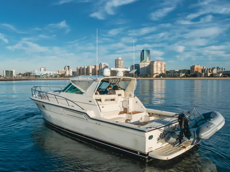 Slide: The Image of 1996 Tiara Yachts 4300 cruising near city skyline on calm water. - 9