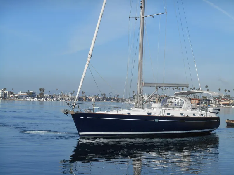 Slide: The Image of Beneteau Oceanis 50 sailboat from 2000 on calm water, clear sky background. - 13