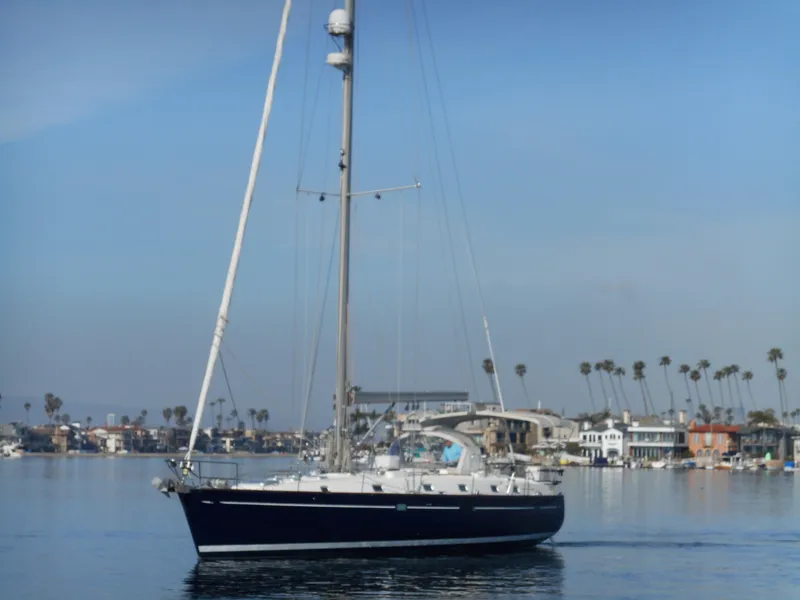 Slide: The Image of Beneteau Oceanis 50 sailboat from 2000 on calm waters near a coastal town. - 14