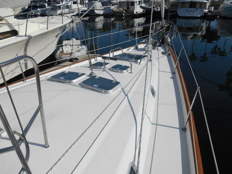 Slide: The Image of Beneteau Oceanis 50 sailboat deck, 2000 model, docked in a marina with other boats. - 18