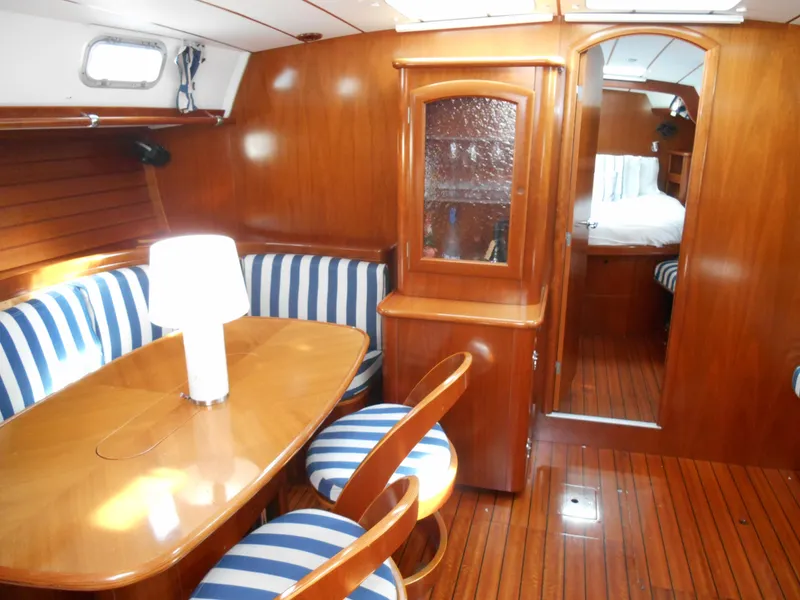Slide: The Image of Interior of 2000 Beneteau Oceanis 50 yacht with wooden furnishings and striped seating. - 23