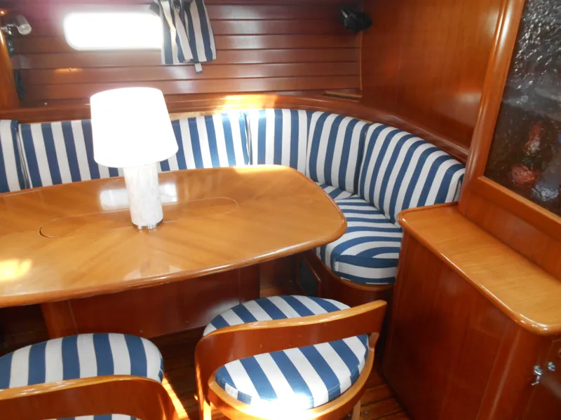 Slide: The Image of Interior of 2000 Beneteau Oceanis 50 with striped seating and wooden table. - 25