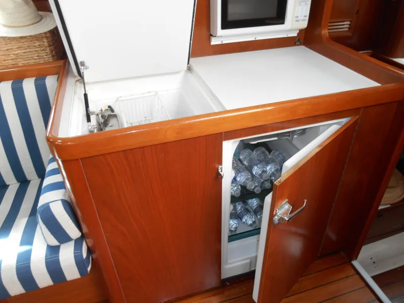 Slide: The Image of Interior of 2000 Beneteau Oceanis 50 yacht with fridge and striped seating. - 30