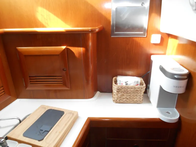 Slide: The Image of Galley of 2000 Beneteau Oceanis 50 yacht with wooden cabinetry and coffee maker. - 32