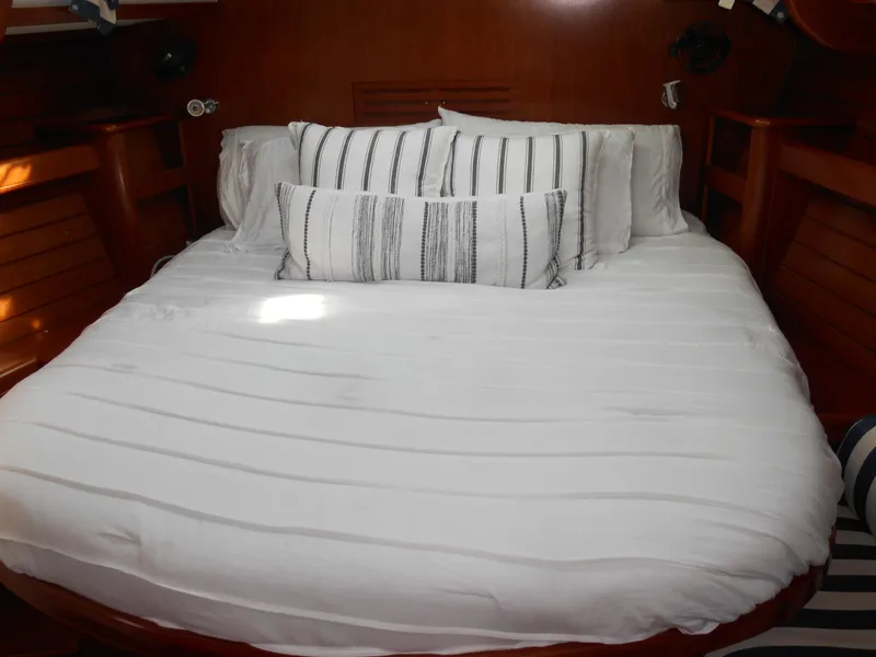 Slide: The Image of Cozy cabin bed in 2000 Beneteau Oceanis 50 sailboat with striped pillows. - 35