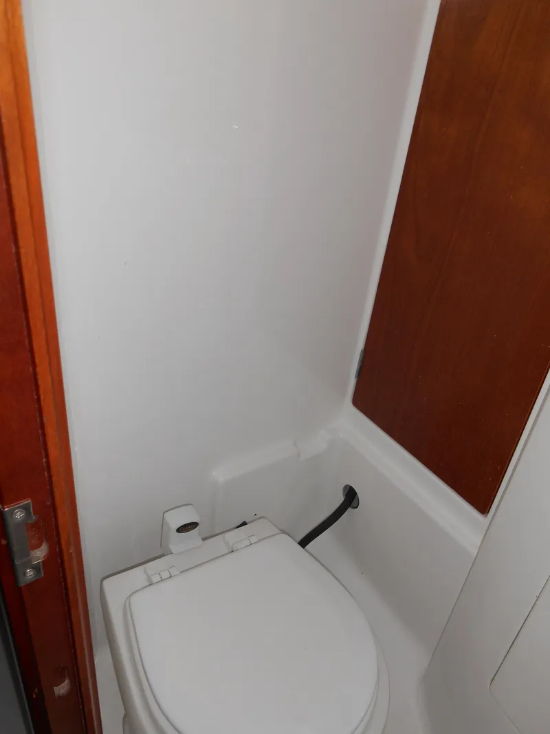 Slide: The Image of Bathroom interior of 2000 Beneteau Oceanis 50 yacht, featuring a compact toilet. - 42
