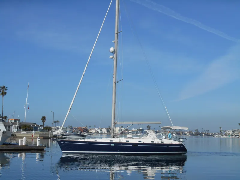 Slide: The Image of Beneteau Oceanis 50 sailboat from 2000 on calm water, clear blue sky background. - 6