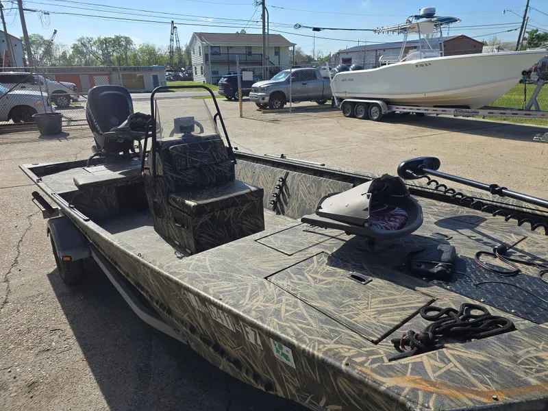 Slide: The Image of 2012 Lowe Roughneck 1860CC boat in a parking lot, featuring camouflage design. - 10