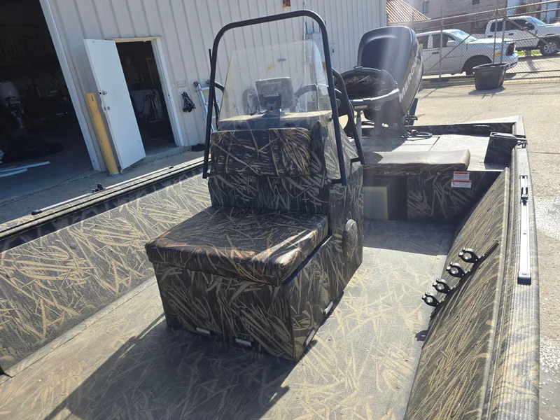 Slide: The Image of 2012 Lowe Roughneck 1860CC boat with camouflage seating and console, parked outdoors. - 7