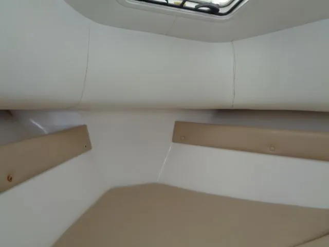 Slide: The Image of Interior cabin of 2007 Century 2200 Walkaround boat, featuring beige seating. - 7