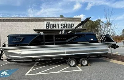 Slide: The Image of 2025 Crest Caribbean 230 boat on trailer outside The Boat Shop. - 1