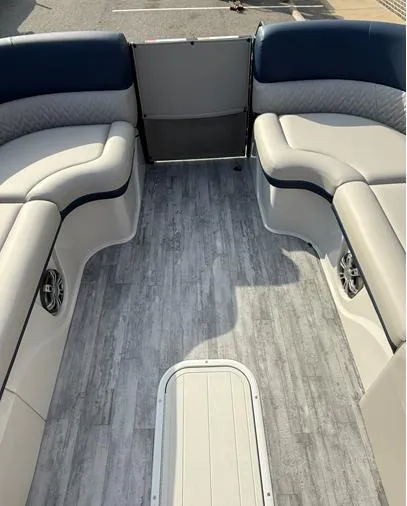 Slide: The Image of 2025 Crest Caribbean 230 boat interior with gray flooring and cushioned seating. - 12