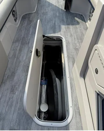 Slide: The Image of 2025 Crest Caribbean 230 boat storage compartment with open hatch on sleek deck. - 13