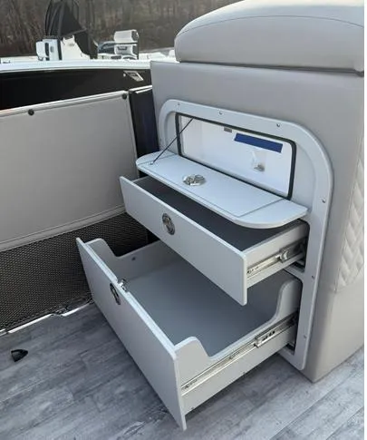 Slide: The Image of 2025 Crest Caribbean 230 boat interior storage compartments with open drawers. - 14