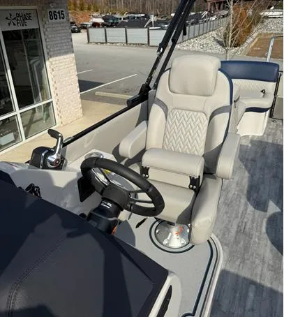 Slide: The Image of 2025 Crest Caribbean 230 boat interior with steering wheel and captain's chair. - 6