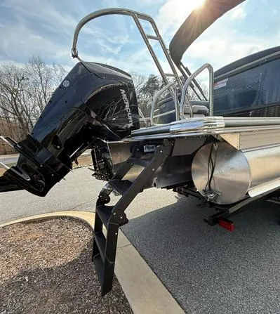 Slide: The Image of 2025 Crest Caribbean 230 boat with Mercury outboard motor and ladder, parked on pavement. - 8