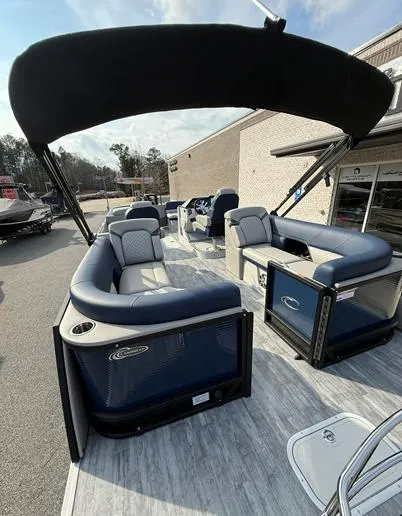 Slide: The Image of 2025 Crest Caribbean 230 pontoon boat with blue seating and canopy, docked outdoors. - 9