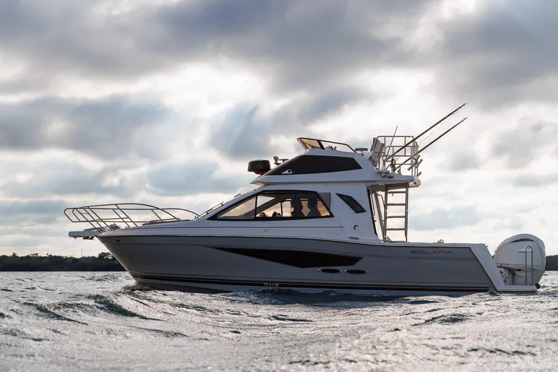 Slide: The Image of 2025 Solara S-310 SB boat cruising on water under cloudy sky. - 2