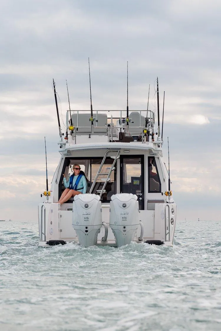 Slide: The Image of 2025 Solara S-310 SB boat on water, equipped with dual engines and fishing rods. - 3