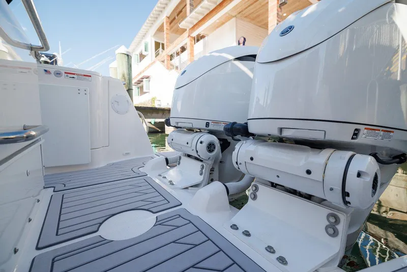 Slide: The Image of 2025 Solara S-310 SB boat with dual outboard engines docked near waterfront homes. - 4