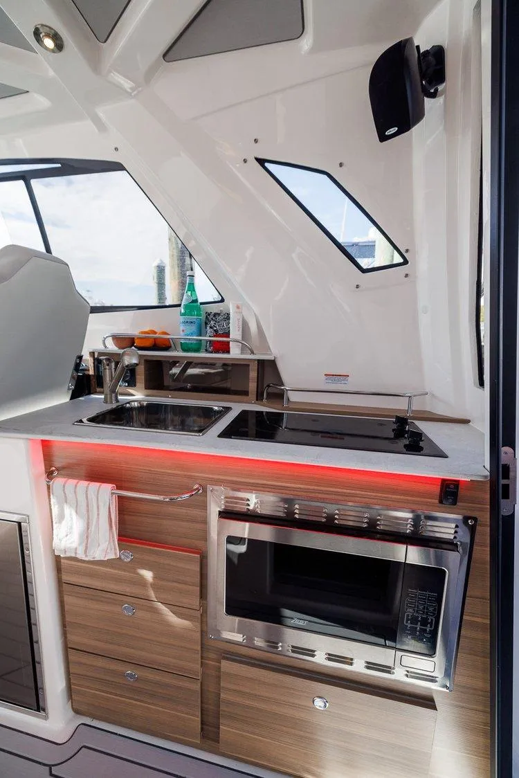Slide: The Image of Modern kitchen area in 2025 Solara S-310 SB boat with sleek appliances and wood cabinetry. - 6