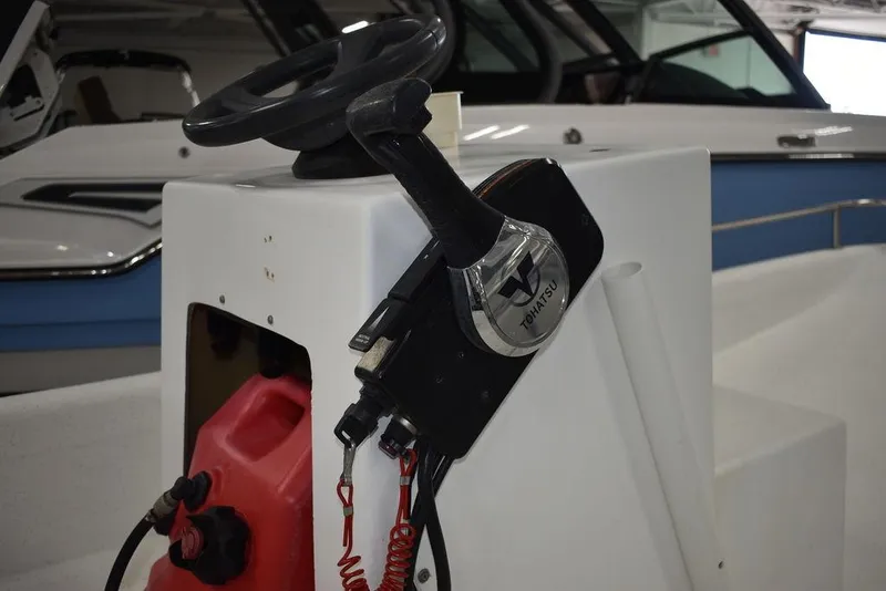 Slide: The Image of 2011 Carolina Skiff J16 steering console with throttle controls and red fuel tank. - 11