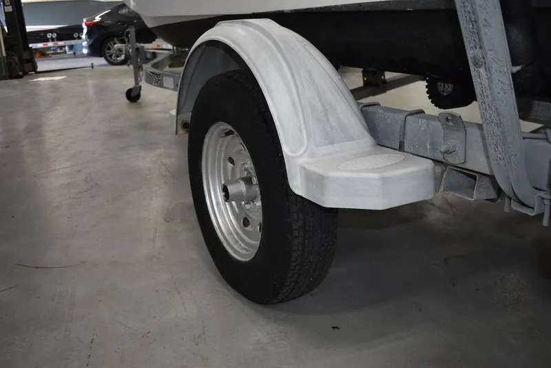 Slide: The Image of Trailer wheel of a 2011 Carolina Skiff J16 boat in a garage setting. - 22