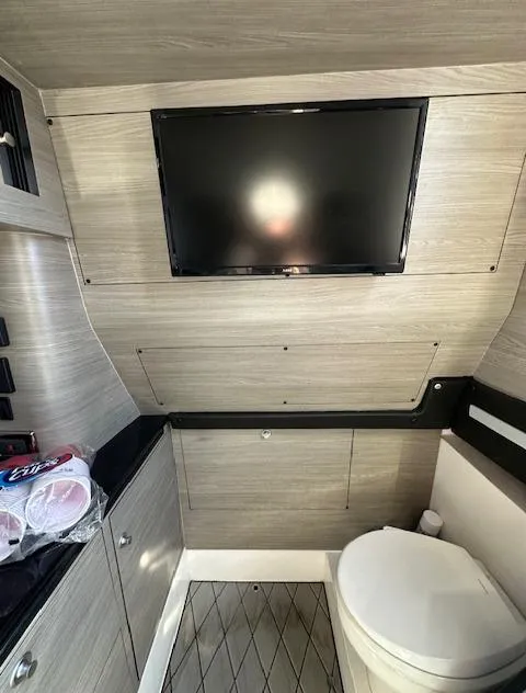 Slide: The Image of 2019 Mystic Powerboats M4200 interior with TV and modern bathroom amenities. - 19