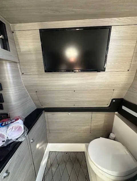 Slide: The Image of 2019 Mystic Powerboats M4200 interior with TV and toilet in modern design. - 21