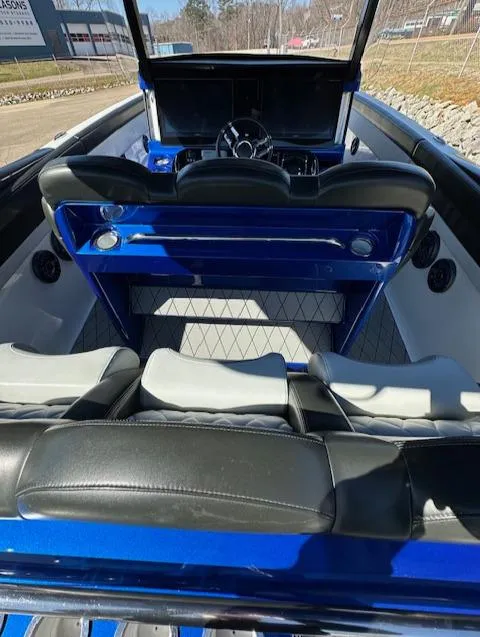 Slide: The Image of 2019 Mystic Powerboats M4200 interior with sleek black and blue seating and modern dashboard. - 7