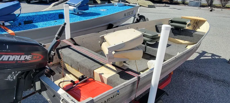 Slide: The Image of 1983 Starcraft SL-14 boat with Evinrude motor, parked on gravel, featuring Garmin equipment. - 2