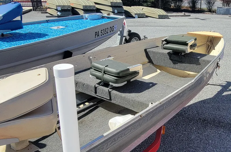 Slide: The Image of 1983 Starcraft SL-14 boat with seating, displayed outdoors on a sunny day. - 3