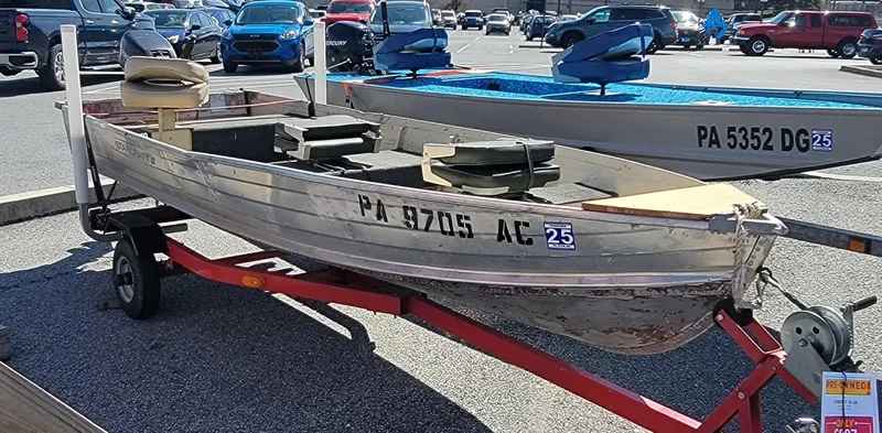Slide: The Image of 1983 Starcraft SL-14 boat on trailer in parking lot, with registration number visible. - 5