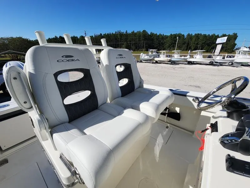 Slide: The Image of 2025 Cobia 265 Center Console boat with dual cushioned seats and steering wheel. - 16