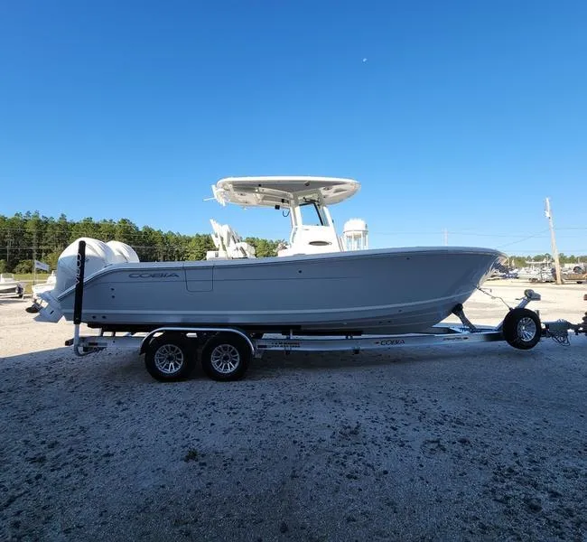 Slide: The Image of 2025 Cobia 265 Center Console boat on trailer under clear blue sky. - 2